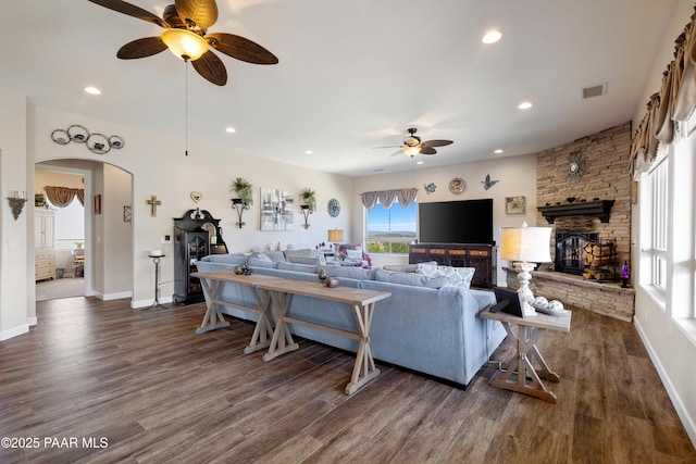 living room featuring visible vents, arched walkways, dark wood-style flooring, and recessed lighting