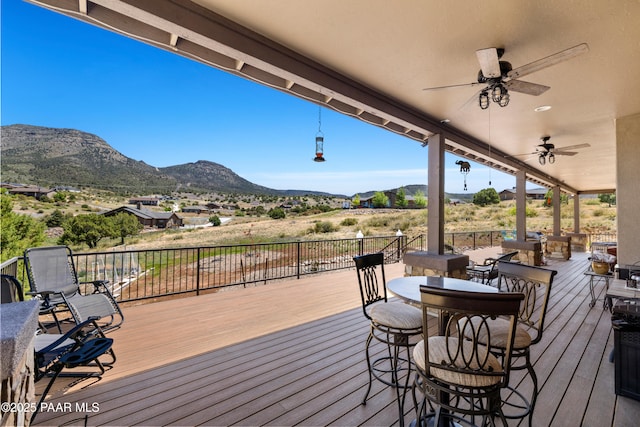 deck with a mountain view and a ceiling fan