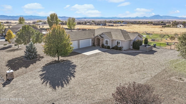 view of front of house with concrete driveway, a garage, a mountain view, and stucco siding