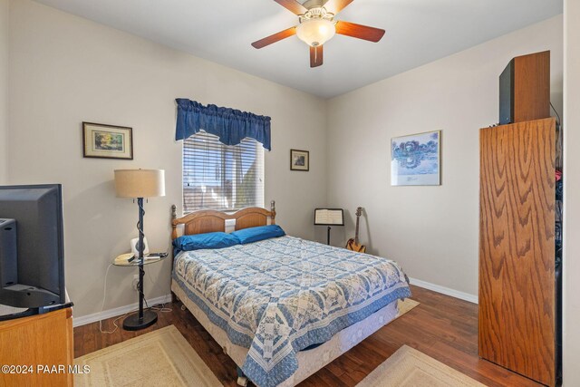 bedroom featuring ceiling fan, baseboards, and wood finished floors