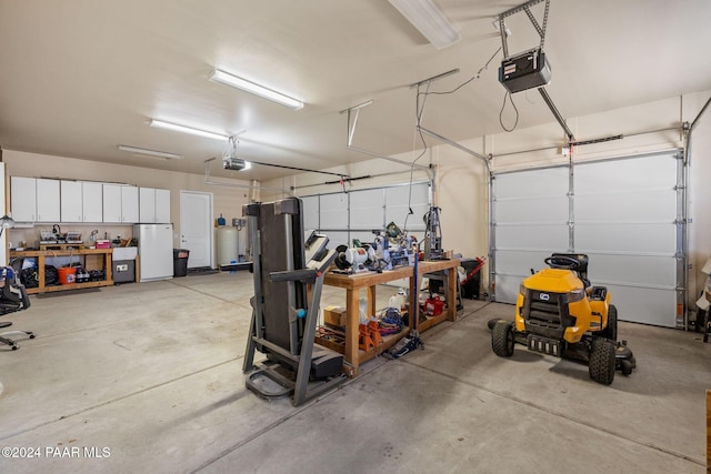 garage featuring a workshop area, a garage door opener, and freestanding refrigerator