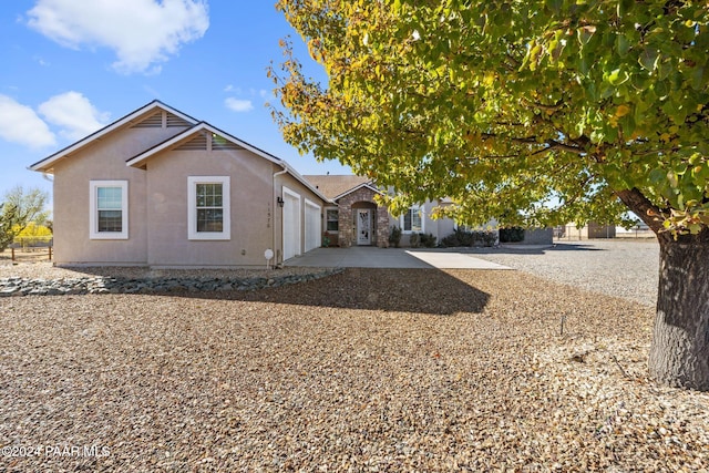 view of front of house with concrete driveway, an attached garage, and stucco siding