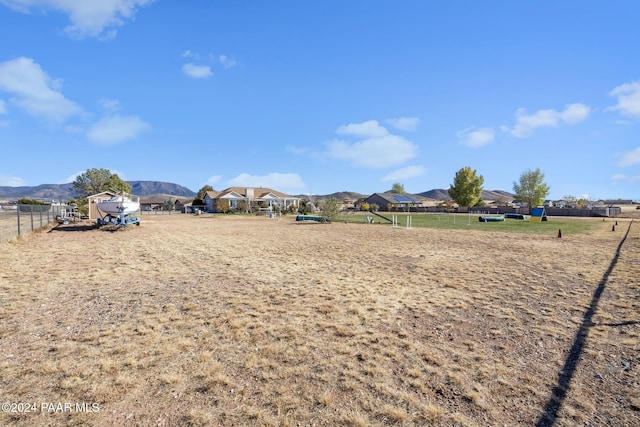 view of yard featuring a mountain view, an enclosed area, and fence