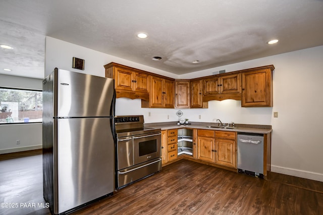 kitchen featuring dark wood-style floors, stainless steel appliances, visible vents, a sink, and baseboards