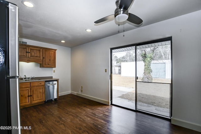 kitchen with brown cabinets, dark wood-style floors, baseboards, and stainless steel appliances