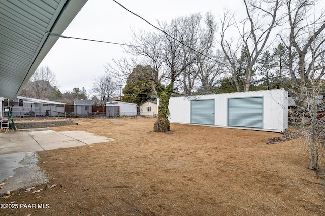 view of yard featuring an outbuilding, a patio area, and fence