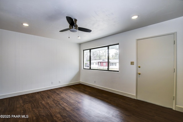 spare room with a ceiling fan, recessed lighting, dark wood-style flooring, and baseboards