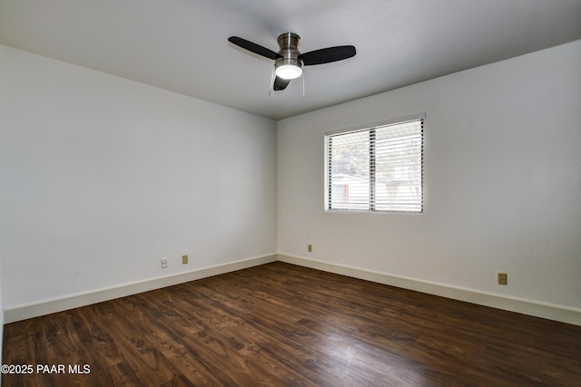 empty room featuring ceiling fan, dark wood finished floors, and baseboards