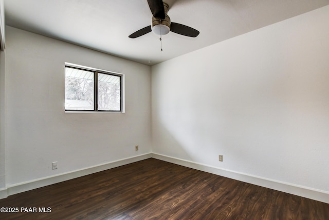 spare room featuring dark wood-style floors, baseboards, and a ceiling fan