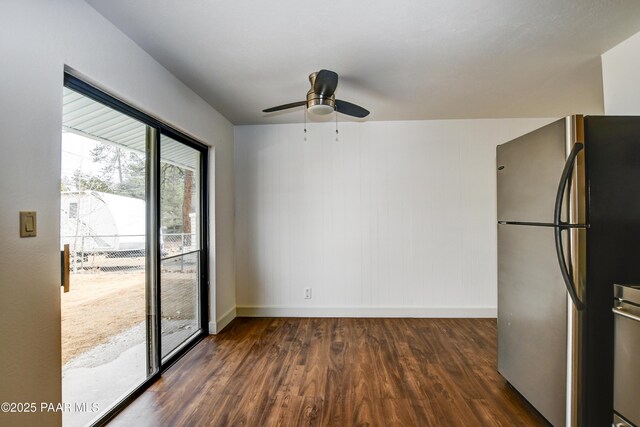 empty room featuring a ceiling fan, baseboards, and wood finished floors