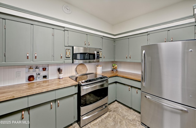 2009 Rocky Dells Dr, Prescott, AZ 86303 - kitchen with appliances with stainless steel finishes, butcher block counters, gray cabinetry, decorative backsplash, and light tile patterned floors