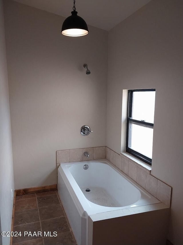 bathroom featuring tile patterned flooring and a relaxing tiled tub