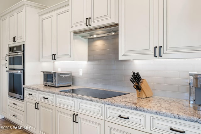 12612 E E Side Saddle Ln, Prescott Valley, AZ 86315 - kitchen featuring stainless steel double oven, black electric cooktop, under cabinet range hood, and tasteful backsplash