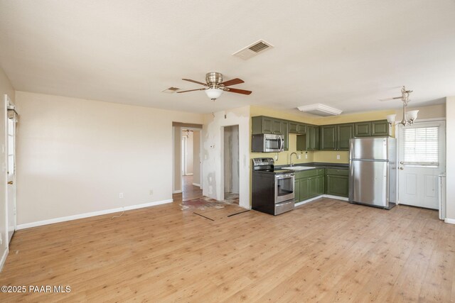 7555 W Wexford Dr, Wilhoit, AZ 86332 - kitchen with appliances with stainless steel finishes, green cabinets, light wood-style floors, and a ceiling fan