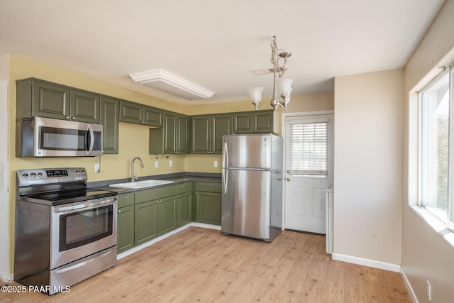 7555 W Wexford Dr, Wilhoit, AZ 86332 - kitchen with appliances with stainless steel finishes, green cabinetry, light wood-type flooring, a chandelier, and pendant lighting