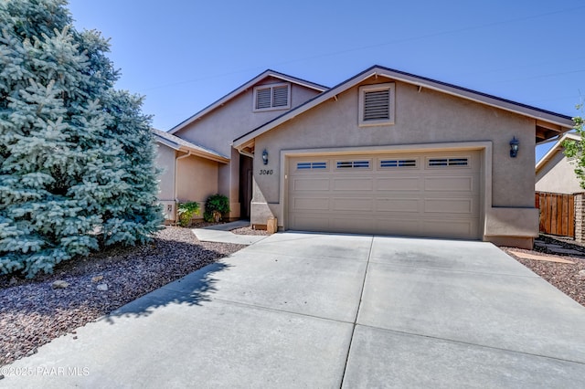 ranch-style house with stucco siding, fence, concrete driveway, and a garage