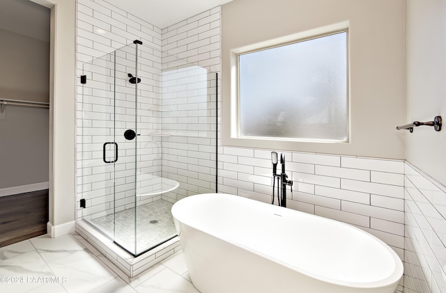 bathroom featuring tile walls and independent shower and bath