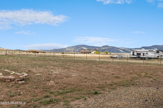 view of yard featuring a mountain view and fence
