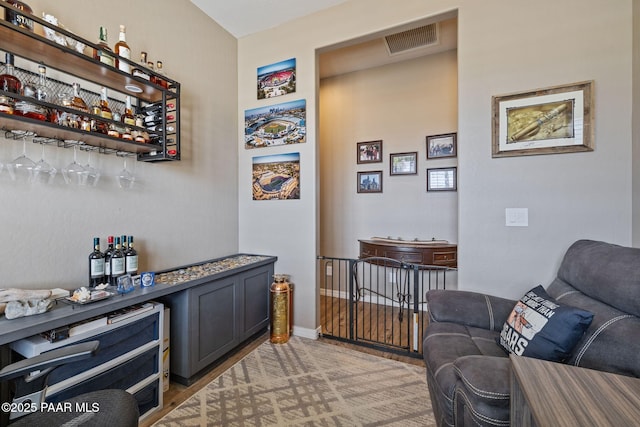 indoor dry bar featuring light wood-style floors
