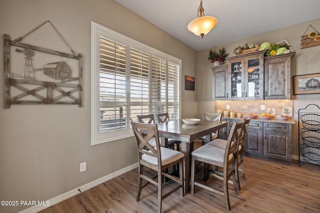 dining space with dark wood-style flooring and baseboards