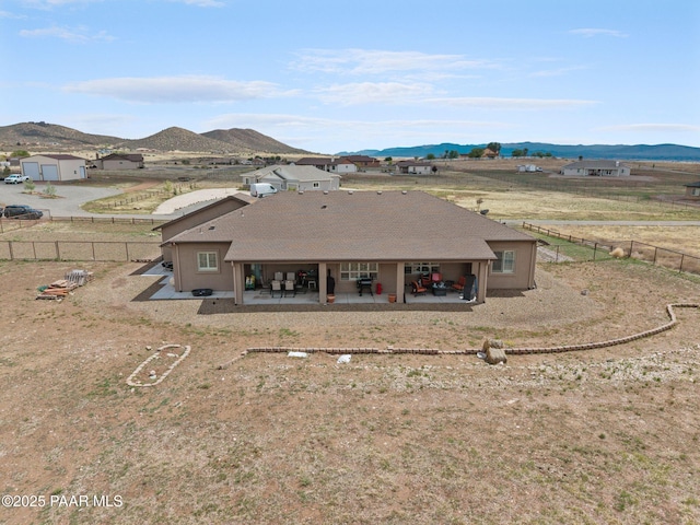 rear view of property featuring a mountain view, a patio area, and a fenced backyard