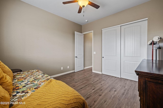 bedroom with wood finished floors, baseboards, a closet, and a ceiling fan
