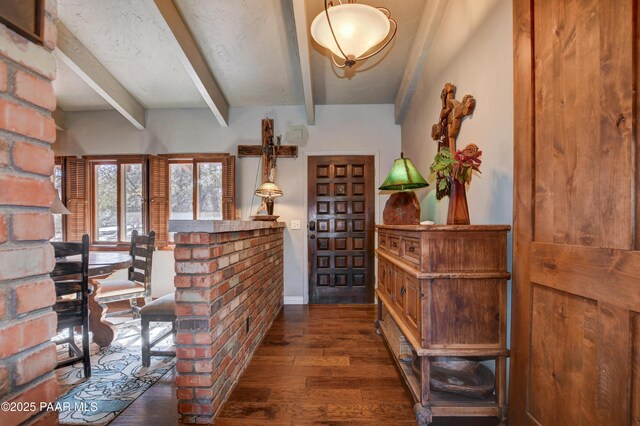 bar featuring dark wood-style floors, a textured ceiling, baseboards, and beam ceiling