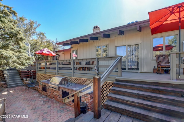 rear view of house featuring a chimney, area for grilling, and a wooden deck
