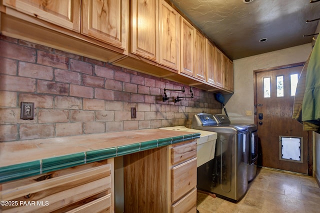 laundry area featuring washer and clothes dryer and cabinet space