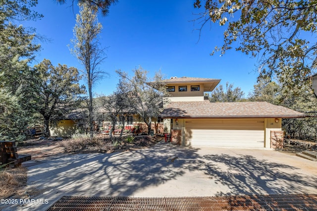 view of front of home with driveway, an attached garage, and brick siding