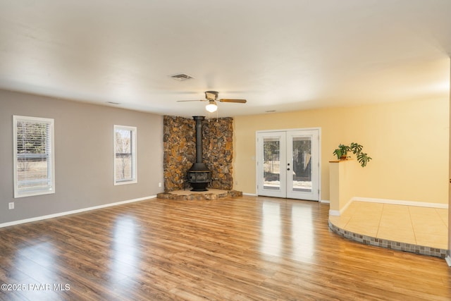 3045 Hozoni Rd, Prescott, AZ 86305 - unfurnished living room with a wood stove, french doors, light wood finished floors, and ceiling fan