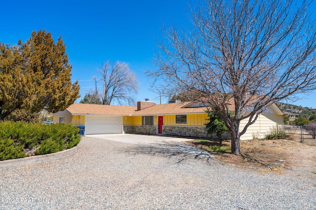 3045 Hozoni Rd, Prescott, AZ 86305 - ranch-style house with board and batten siding, an attached garage, concrete driveway, a chimney, and stone siding
