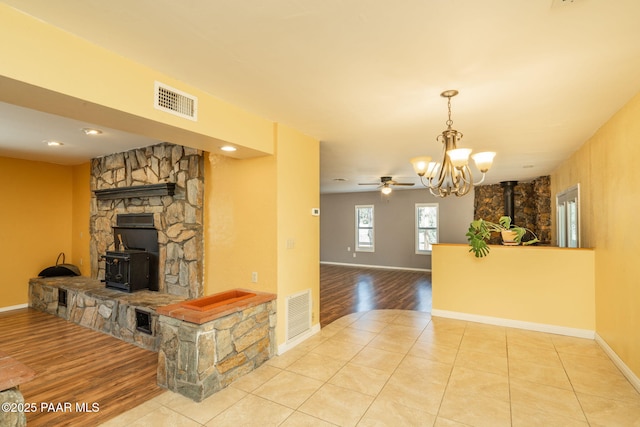 3045 Hozoni Rd, Prescott, AZ 86305 - unfurnished living room featuring a wood stove, wood finished floors, a chandelier, and baseboards
