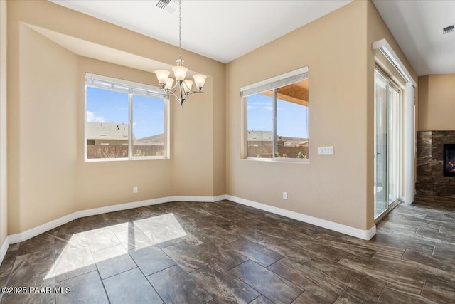 unfurnished dining area with a wealth of natural light, baseboards, and a lit fireplace