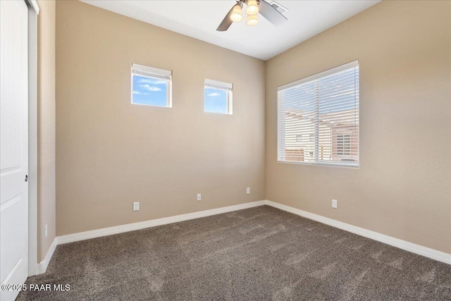 unfurnished room featuring baseboards, ceiling fan, and dark carpet