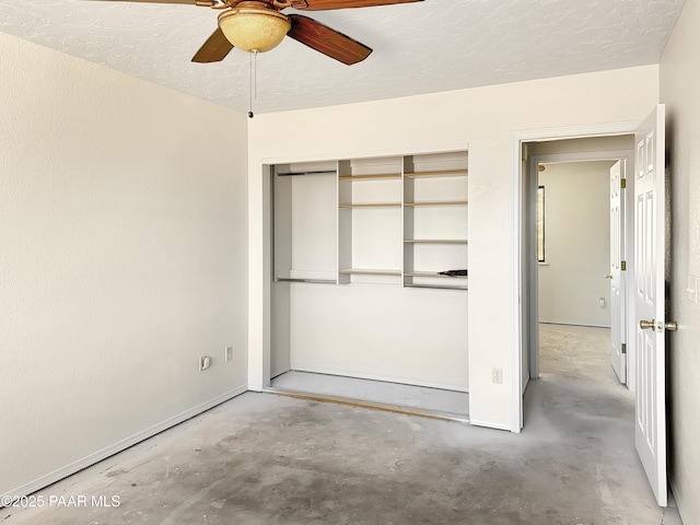 unfurnished bedroom featuring unfinished concrete floors, baseboards, a closet, a textured ceiling, and a ceiling fan