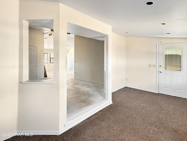 empty room featuring baseboards, carpet, and a ceiling fan