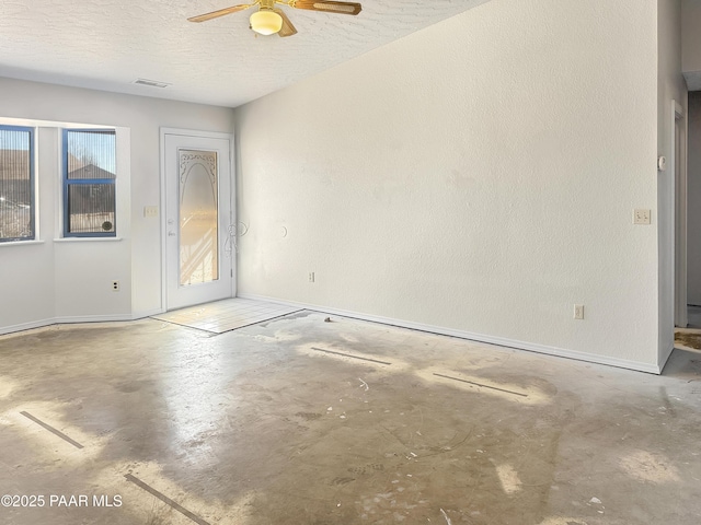 unfurnished room featuring visible vents, baseboards, ceiling fan, concrete flooring, and a textured ceiling