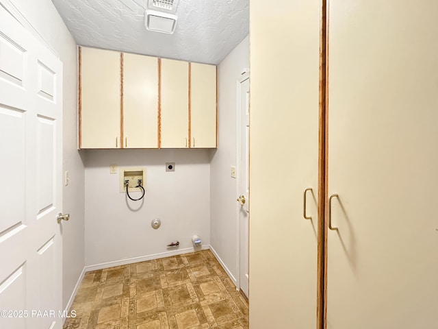 clothes washing area featuring electric dryer hookup, washer hookup, a textured ceiling, cabinet space, and gas dryer hookup