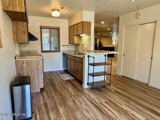 3169 Dome Rock Pl Unit 12A, Prescott, AZ 86301 - kitchen featuring a sink, dark wood-style floors, brown cabinetry, dishwashing machine, and range hood