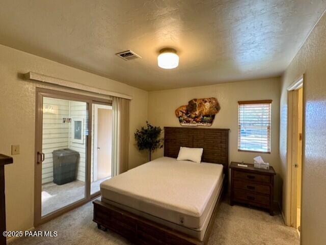 3169 Dome Rock Pl Unit 12A, Prescott, AZ 86301 - bedroom featuring light colored carpet, access to outside, and a textured ceiling