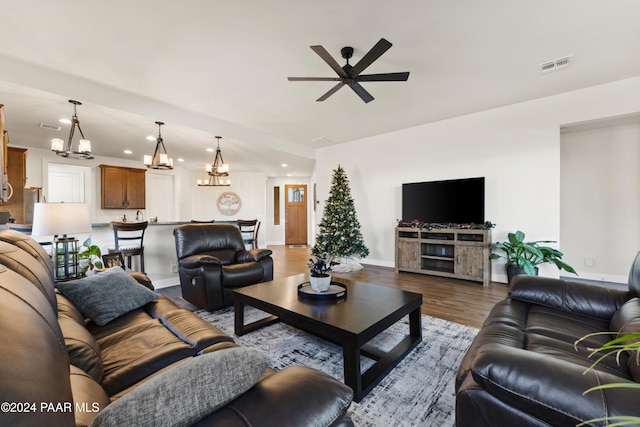 living room featuring hardwood / wood-style flooring and ceiling fan with notable chandelier