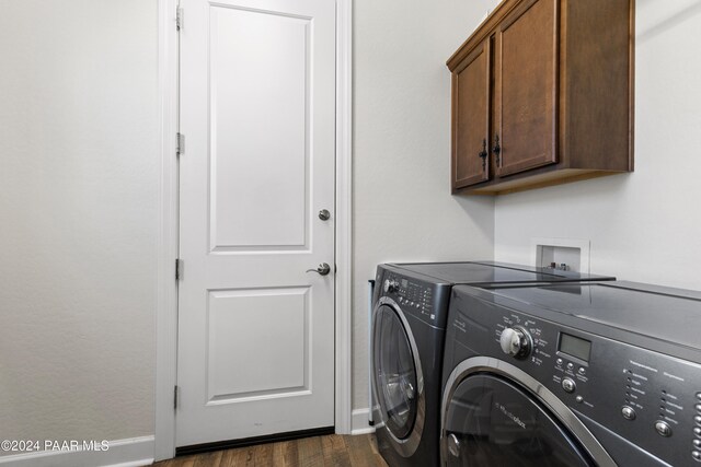 laundry room with dark hardwood / wood-style flooring, cabinets, and independent washer and dryer