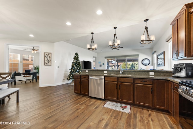 kitchen with dark wood-type flooring, ceiling fan with notable chandelier, sink, a wealth of natural light, and appliances with stainless steel finishes