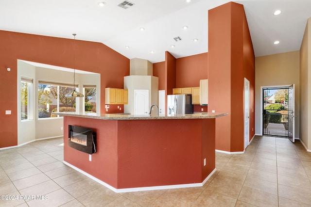 kitchen featuring a large island, plenty of natural light, pendant lighting, and stainless steel refrigerator with ice dispenser