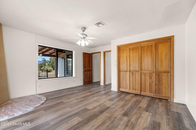 unfurnished bedroom featuring ceiling fan and dark wood-type flooring