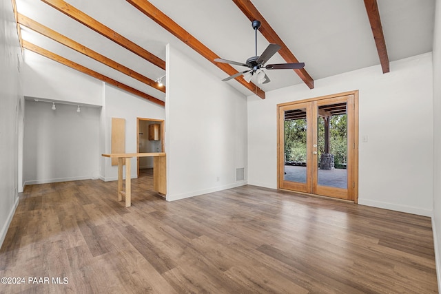 unfurnished living room with ceiling fan, french doors, hardwood / wood-style flooring, and lofted ceiling with beams