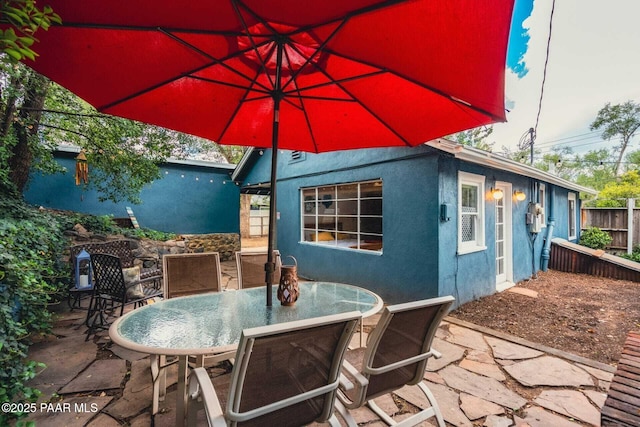 view of patio / terrace featuring outdoor dining area and fence