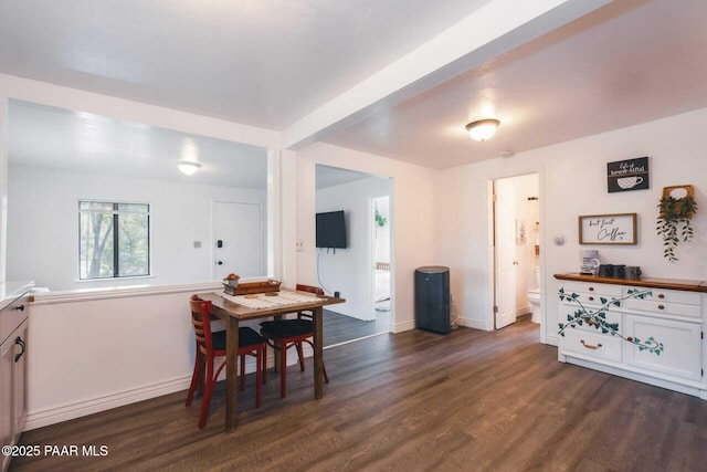 dining room featuring dark wood finished floors and baseboards