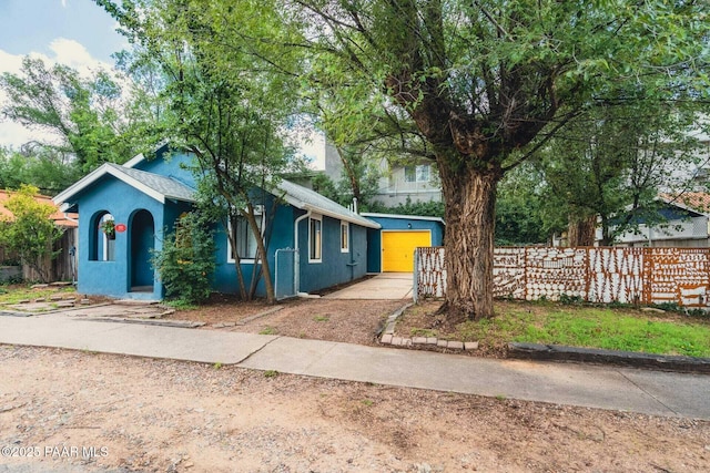 view of front of house with fence and stucco siding